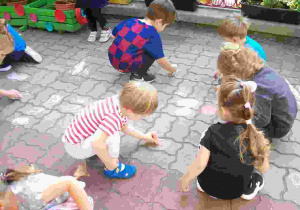 Dzieci z I grupy malują kolorową kredą na tarasie piękne krop0ki8